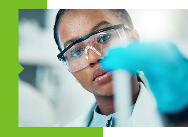 A scientist in a lab coat and glasses holding a test tube.